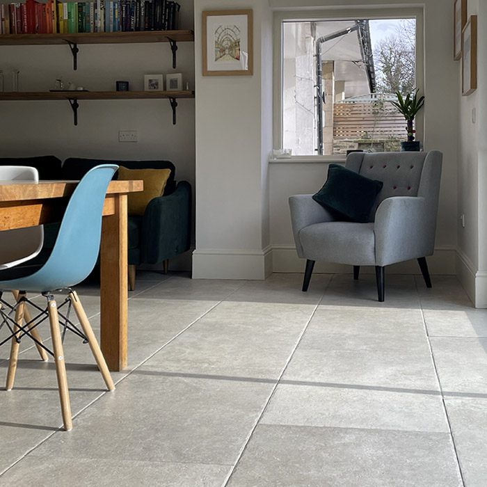 Large antique stone-effect floor tiles in an open plan living dining area